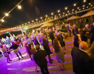 crowd of people dancing outside under lights